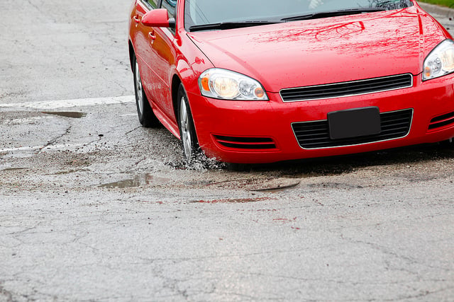 Red Car Stuck in Pothole