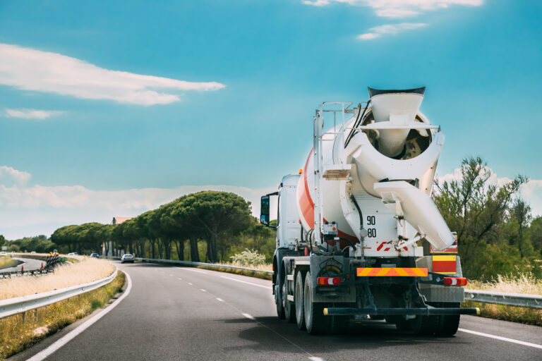 Special Concrete Transport Truck In-transit Mixer Unit In Motion On Country Road, Freeway. Freeway Motorway Highway. Business Drive Transportation And Development Concept. Concrete Truck Mixer