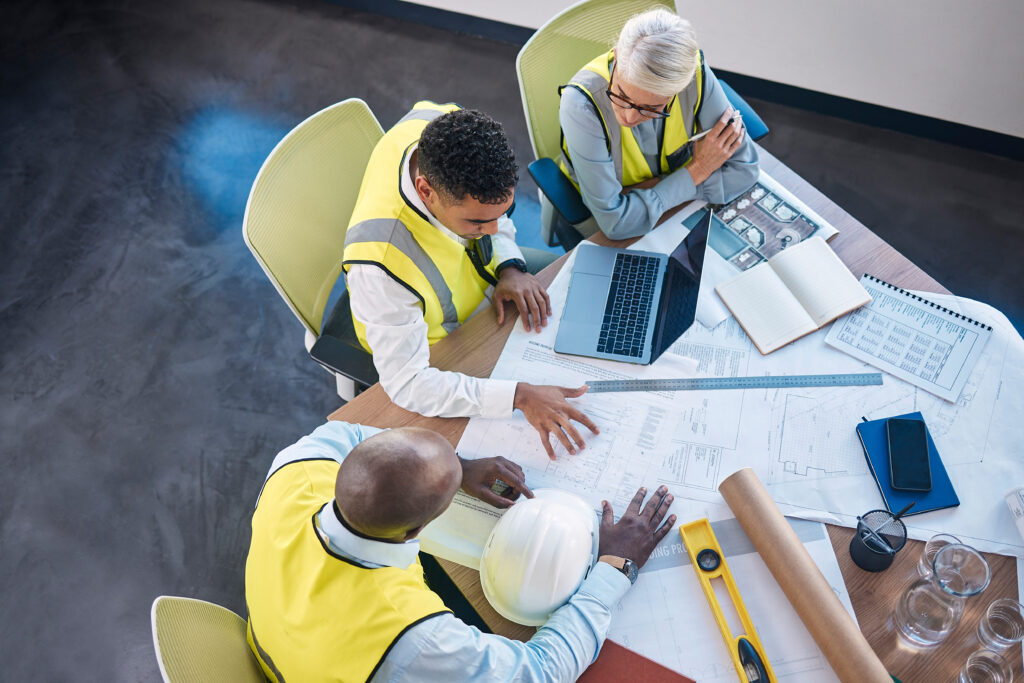Architect, laptop and team in meeting above for construction or building planning strategy at office.