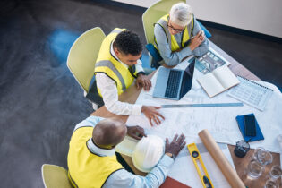 Architect, laptop and team in meeting above for construction or building planning strategy at office.
