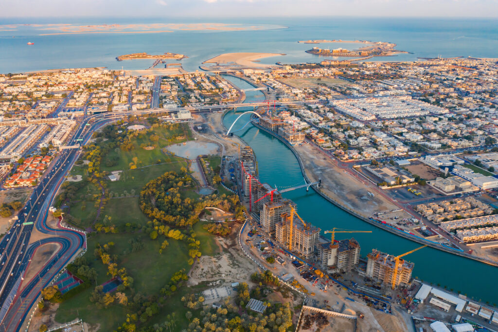 Aerial view of Tolerance bridge. Structure of architecture with lake or river, Dubai Downtown skyline, United Arab Emirates or UAE. Financial district and business area in urban city.
