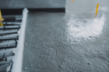 Workers pouring and finishing concrete surface flooring